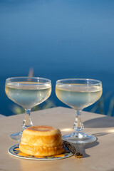 Sweet italian dessert ricotta cheese baked with lemon and glasses of Prosecco sparkling wine served on Ligurian coast with view on sea, summer in Italy