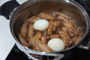 鶏手羽中の煮物を作る様子
