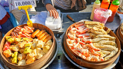 Tulungagung, Indonesia Oktober 25, 2024: The vendor serves various types of dim sum served in bamboo containers which are very appetizing.