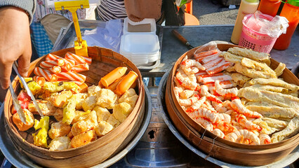 Tulungagung, Indonesia Oktober 25, 2024: The vendor serves various types of dim sum served in bamboo containers which are very appetizing.