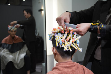 パーマロッドを巻く美容師