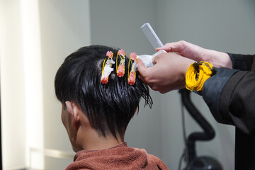 Fototapeta premium パーマロッドを巻く美容師