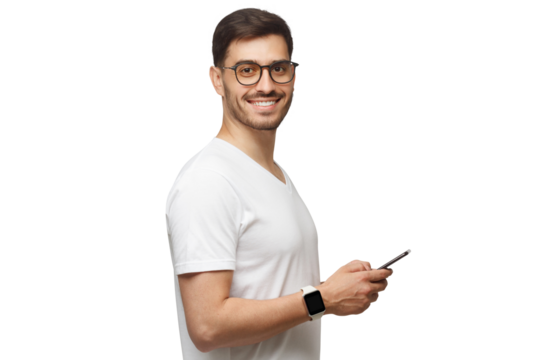 Side shot of young man in white t-shirt, wearing smartwatch on wrist, holding phone and looking at camera with smile