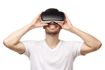 Young smiling man wearing t-shirt and virtual reality headset or VR glasses, playing video game