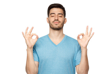 Concentrated relaxed man standing with closed eyes, having relaxation while meditating, trying to...