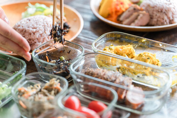 キッチンでワンプレートランチを盛り付ける主婦の手元
