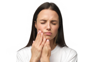 Young woman experiencing severe toothache, pressing hands to cheek, closing eyes because of strong teeth pain