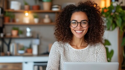A woman with curly hair is smiling and working on a laptop in a cozy home office, highlighting a comfortable and productive remote work environment.