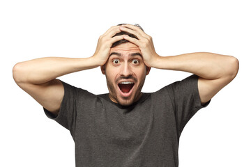 Emotional young man with round eyes, open mouth and hands pressed to top of head, showing...