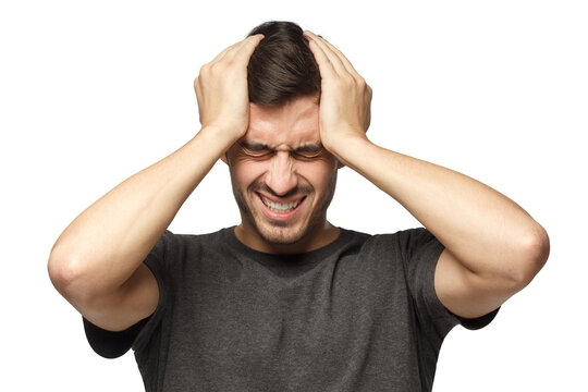 Headache concept. Young man squeezing head with hands. People, stress, tension and migraine concept