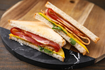Delicious sandwiches with bacon on wooden table, closeup