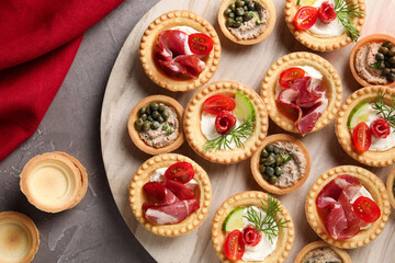 Delicious canapes on grey textured table, flat lay