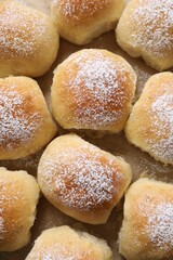 Delicious dough balls on parchment paper, top view