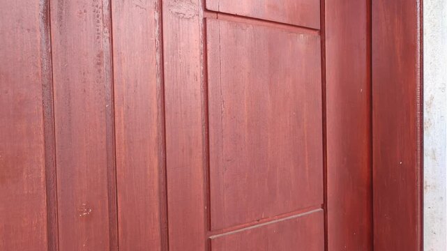 Knocking on the wooden door of the house