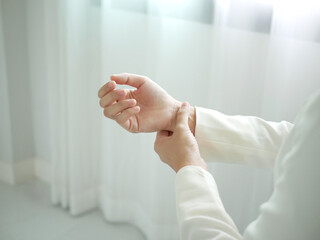 A young businesswoman has severe pain in her wrist. She has numbness. She massages her arm by...