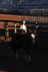 menina vaqueira cavalgando com cavalo marrom 