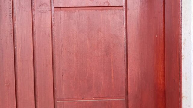 Knocking on the wooden door of the house