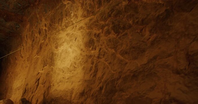 Adventurer riding on line through large cave - slow motion
