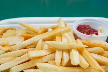 Delicious french fries on eco-friendly plate with ketchup for dipping.