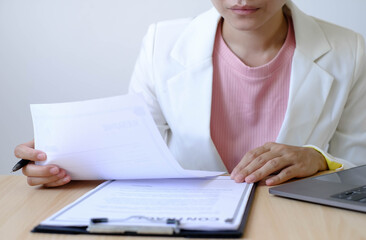 Fototapeta premium Business woman employer holding resume hiring recruit looking cv resume to hire candidates, analyzing information before job interview. Recruitment concepts
