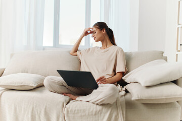 Fototapeta premium Smiling Woman using Laptop at Home, Enjoying Freelance Technology Job in Modern Domestic Setting