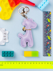 Funny leather keychain lilac giraffe on the desk with office supplies