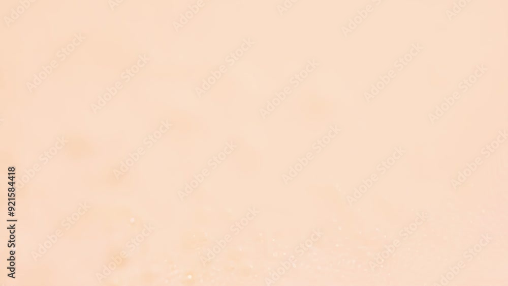 Poster water droplets glisten on a soft pink surface, creating a serene and calming visual effect.