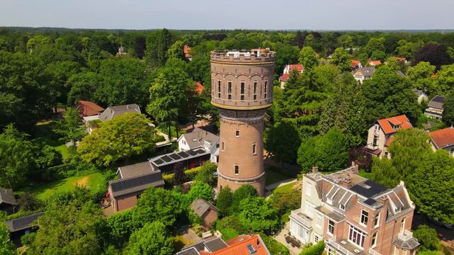 A bird's-eye view of the iconic water tower in Baarn, Netherlands, set amidst charming homes and verdant gardens, capturing the blend of history and nature in this quaint town.