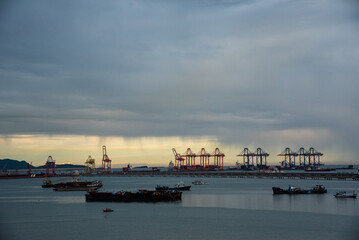 Obraz premium Logistic shipping quay boat in twilight sky night Engineering crane depot at logistic export terminal control. Warehouse freight background container yard loading quayside harbor port Logistics.