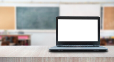 Fototapeta premium Laptop on table in modern office with school background. Cropped shot of wooden table and copy space in blurred study room.