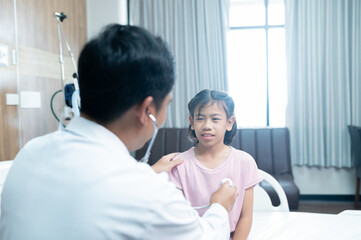 Obraz premium Asian doctor examines young girl in examination room