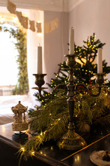 Beautiful vintage candlestick and Carousel music box close up. Home decoration with Christmas tree in blurred lights. Warm and cozy festive background, vertical photo