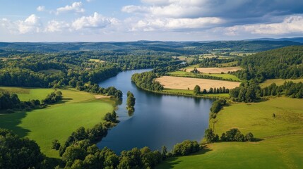 Aerial View of a Winding River Through Lush Green Fields