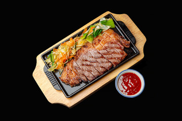 Angus beef steak in a hot black pan with dipping sauce ready to eat.