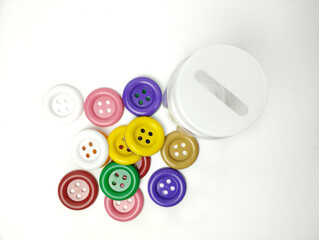 Colorful plastic buttons and perforated jar isolated on white background