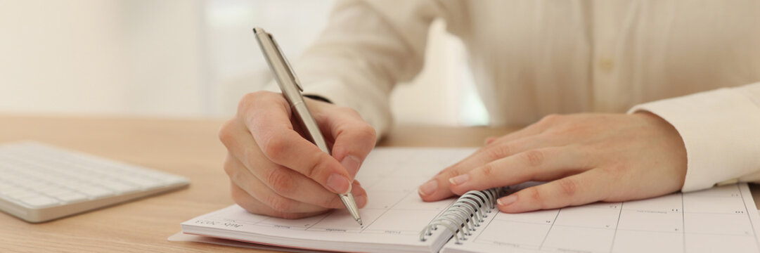 Woman planning business and taking notes in office