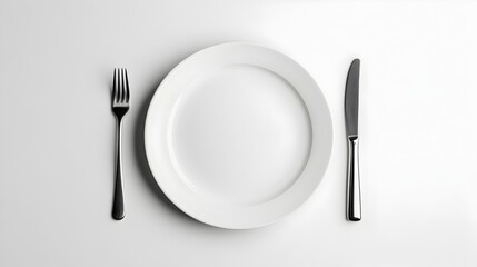 Clean White Ceramic Plate with Metallic Cutlery on Plain Background
