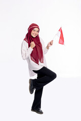 Happy Indonesian female in red hijab standing holding flag