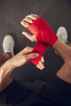 Man, boxer and wrapping hand with bandage above for self defense, fight or workout at indoor gym. Top view or closeup of male person or fighter with strap on knuckles for boxing saftey or protection