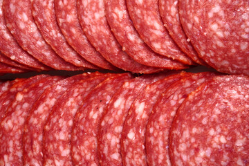 Solid background of sliced smoked sausage.