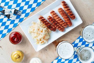 Beer and grilled sausages (curry wurst) on wooden table, top view. Oktoberfest is a German beer and street food festival.