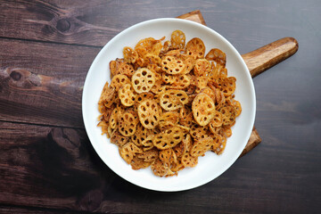 Crispy lotus stem chips, perfectly spiced and golden brown, offer a delightful crunch and unique flavor. Ideal for snacking or as a gourmet appetizer. kurkuri Kamal kakdi. copy space.