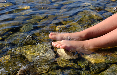 Teenager girl relaxing in water, barefoot in clear cool water. Healthy lifestyle. Young woman...