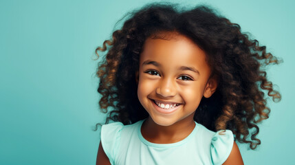 Portrait of smiling cute African American child girl with perfect skin, light blue background, banner.