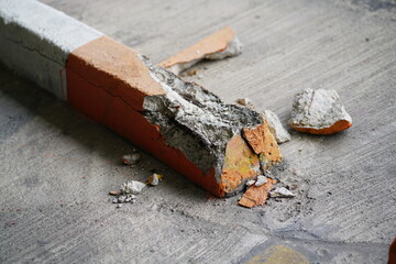 Damaged Concrete Parking Stop Block, Cracked concrete surface with visible rusty reinforcement of...