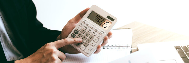 Business and tax concept with business man holding calculator.