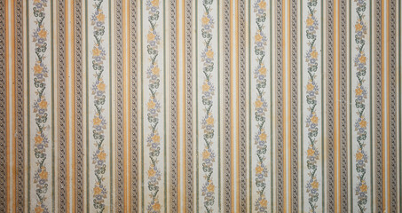 Old wallpaper on the wall. Old wallpaper for texture or background.