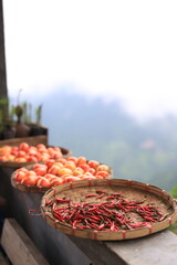Drying chili in a bamboo basket under the sun There is fog on the mountain.
