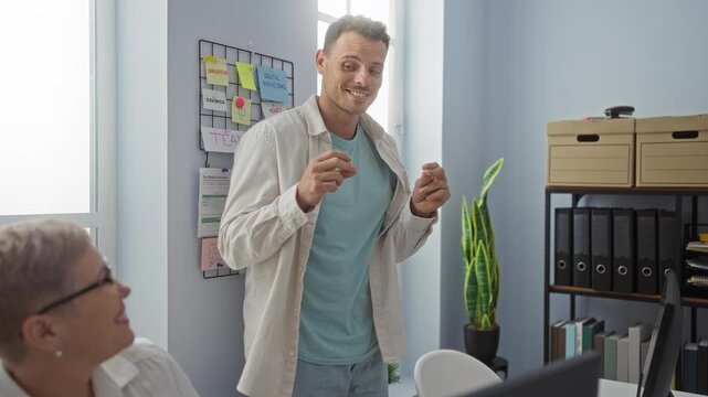 Woman and man coworkers celebrating in a brightly lit office room adorned with motivational notes and office supplies