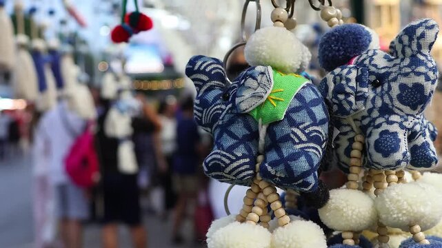 Bokeh view of street lights and blurred tourists. Crowds of Thai and foreign shoppers enjoy hanging out at Chatuchak Weekend Market, Bangkok. People walk, shop, eat, and take photos around the market.